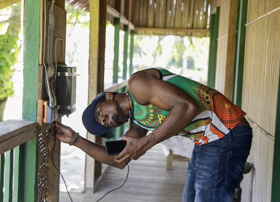 Man charges phone by solar charging station