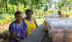 Nancy Apelis and Miriam Enoch, residents of Dabonot Village, New Ireland, make the most of solar power in the evenings to prepare food to sell at the market
